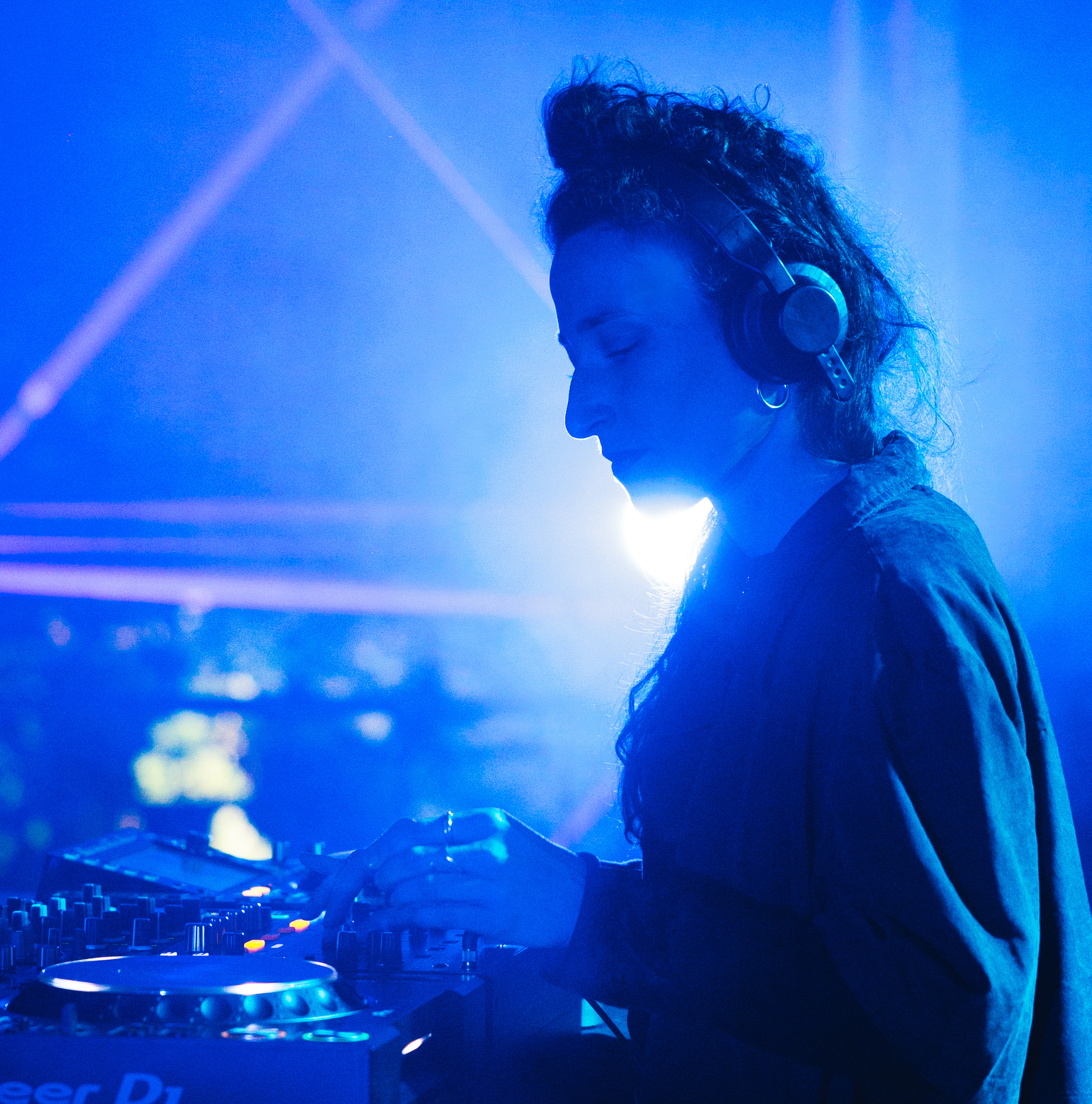 Blanca Brusci, avec un casque de son, actionnant les touches d'une platine de DJ