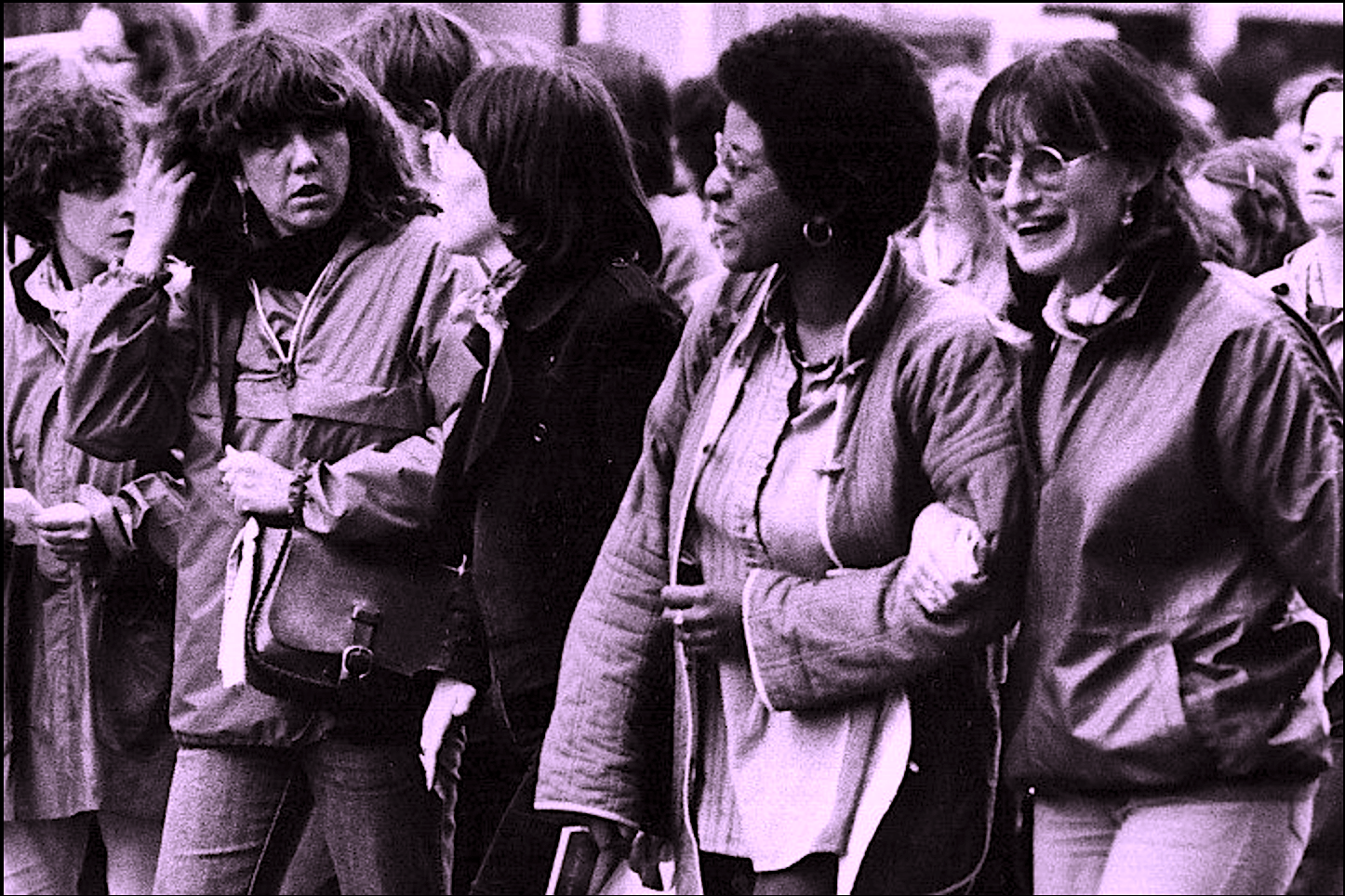 Image d'archive de manifestation de femmes dans les années 1970 se tenant bras-dessus bras-desous.