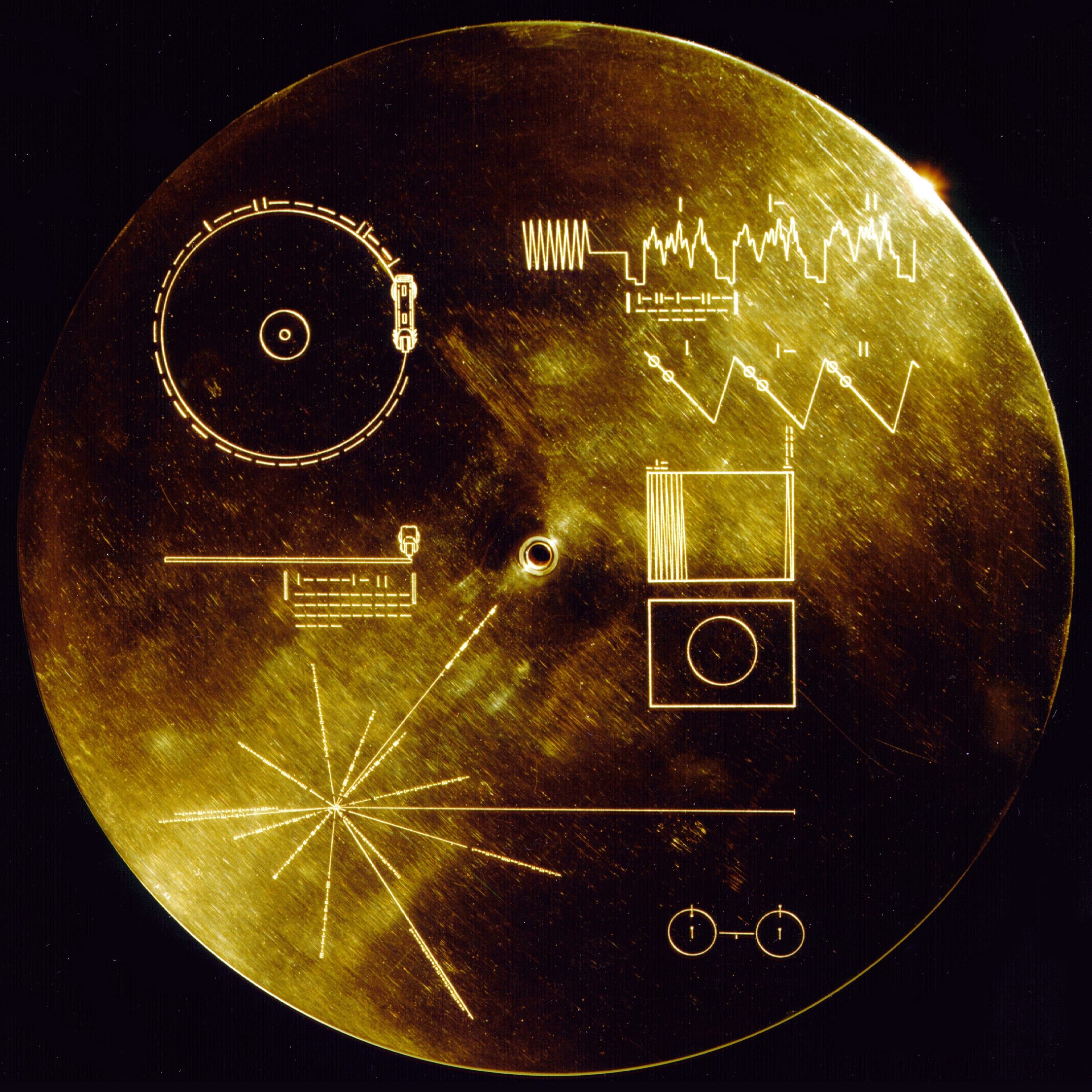 Disque en métal jaune brillant gravé de symboles simples expliquant la position de la terre et envoyé par la sonde Voyager dans l'univers.