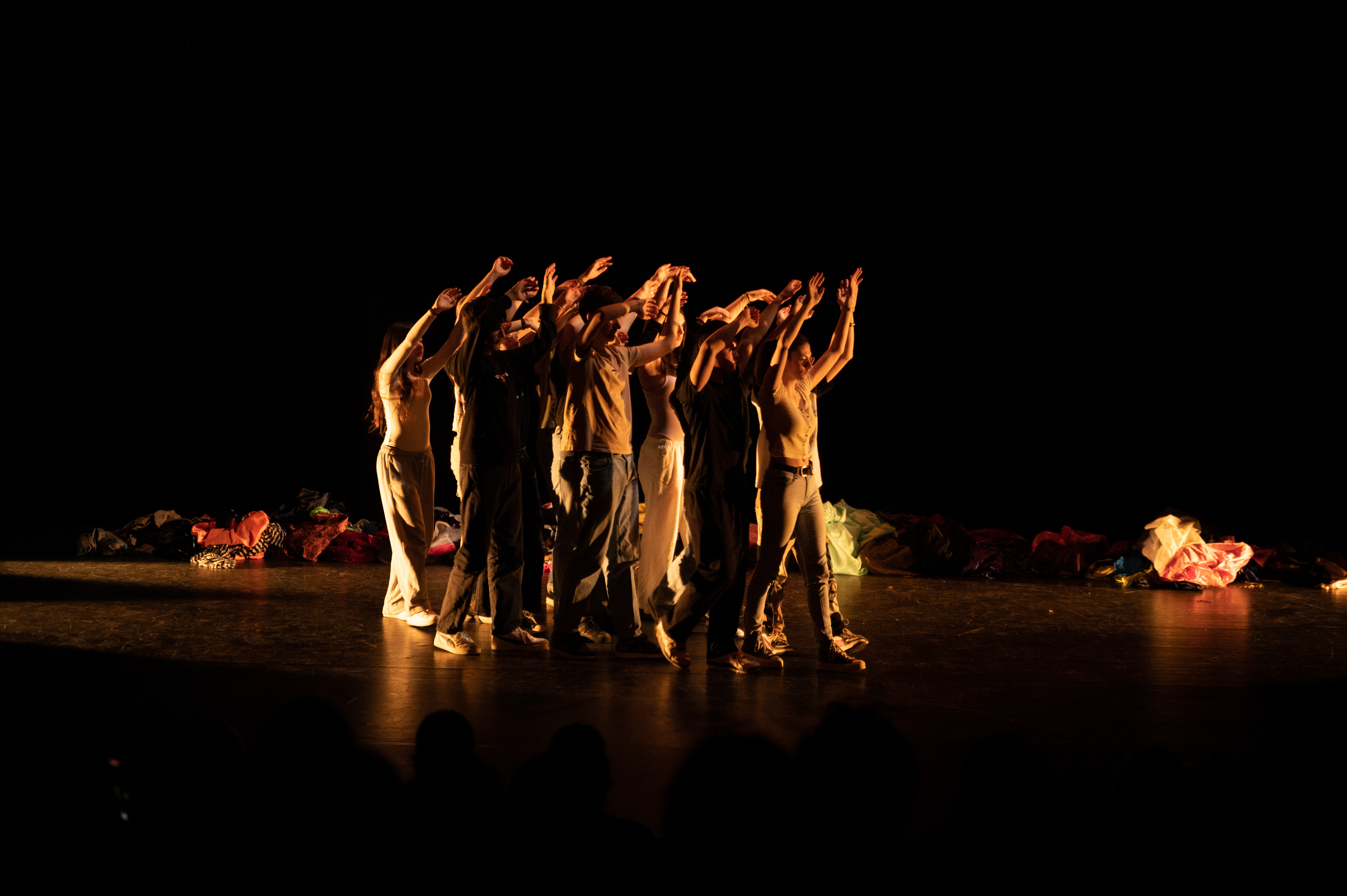 Groupe d'adolescent.es sur scène, les bras levés
