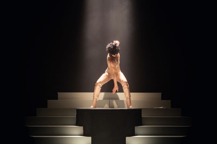 Un personnage est sur un podium en train de danse.